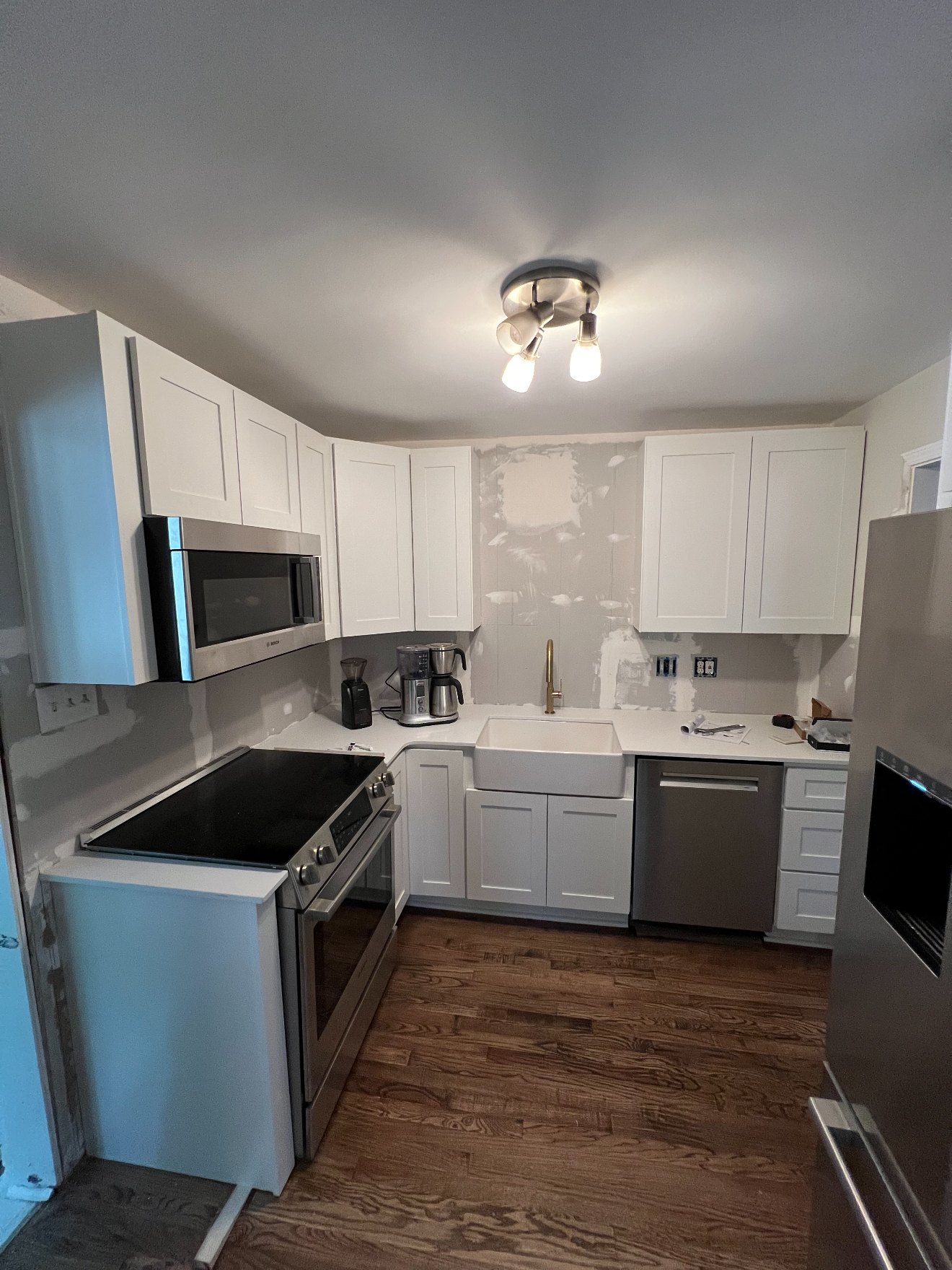 Kitchen cabinet installation in progress showing cabinetry set before finish work is complete